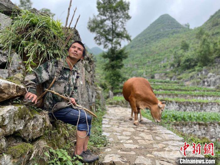 图为一位农民坐在“大寨田”的石梗上休息。　缪超 摄